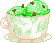 a white teacup with a green leaf pattern with mint chocolate chip ice cream inside